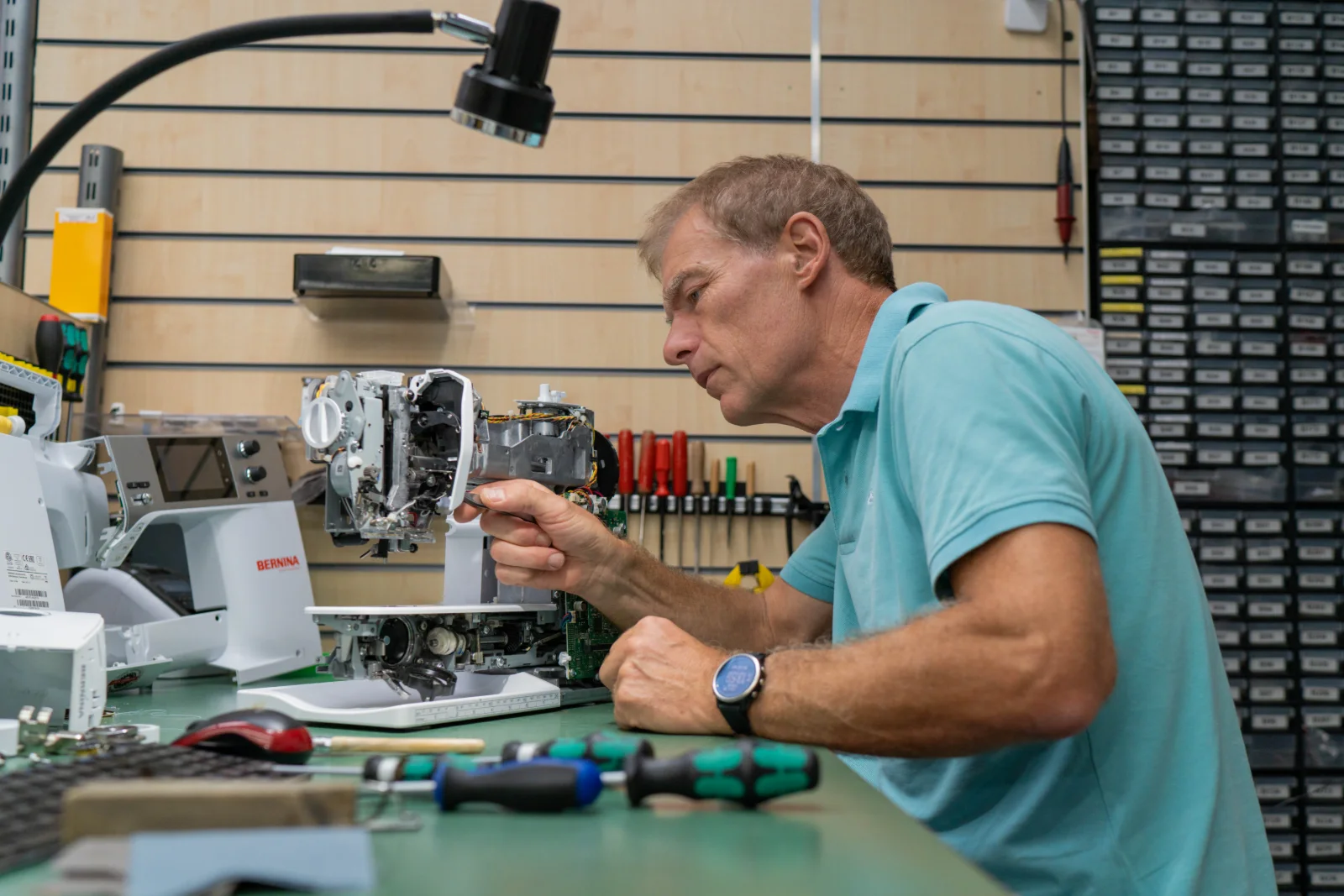Jens Bederke repariert eine Bernina Nähmaschine in der Werkstatt des Nähdschungels